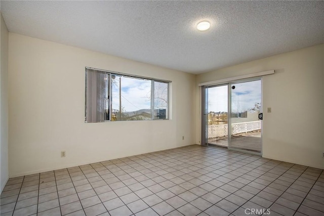 tiled empty room with a textured ceiling