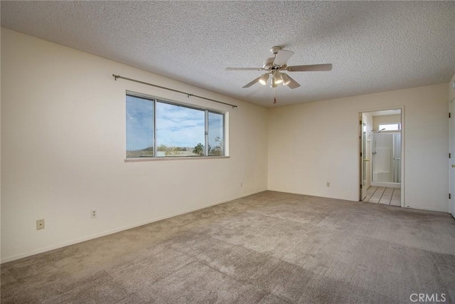 carpeted spare room featuring ceiling fan and a textured ceiling