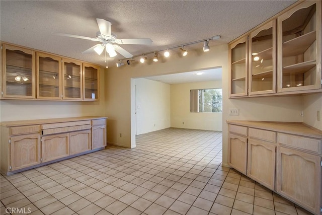 kitchen featuring ceiling fan, light tile patterned floors, a textured ceiling, and light brown cabinets