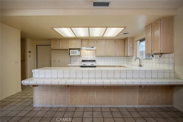 kitchen featuring light brown cabinetry, sink, range with electric stovetop, kitchen peninsula, and decorative backsplash