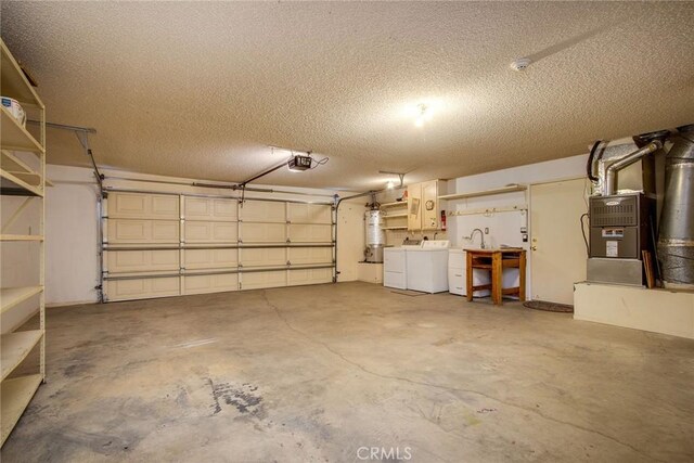 garage featuring a garage door opener, washer and dryer, and strapped water heater