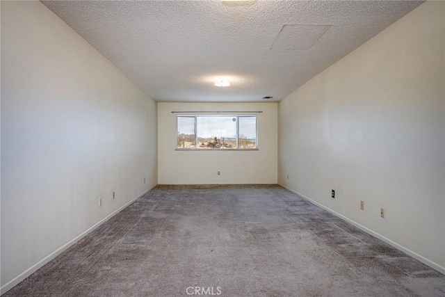 carpeted empty room featuring a textured ceiling