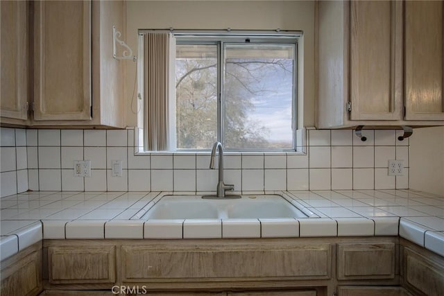 kitchen featuring sink, tile countertops, and decorative backsplash