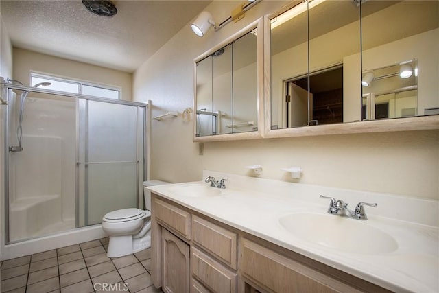 bathroom with tile patterned flooring, an enclosed shower, vanity, a textured ceiling, and toilet