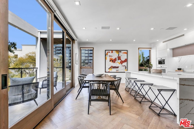 dining space featuring light parquet flooring and crown molding