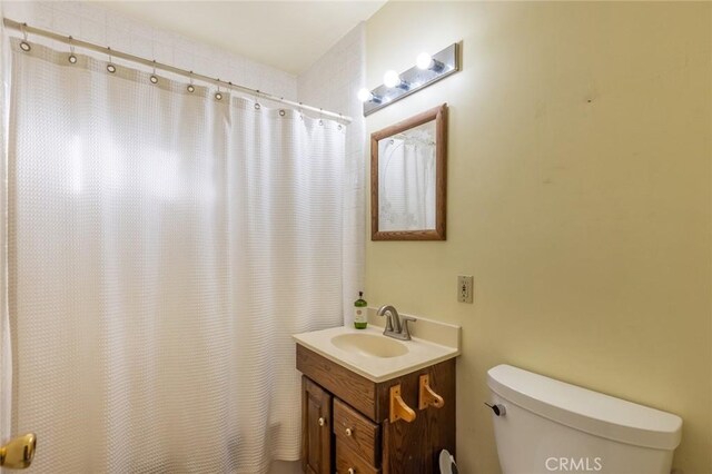 bathroom with a shower with curtain, vanity, and toilet