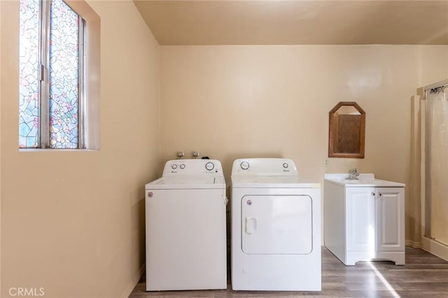 clothes washing area with independent washer and dryer, dark hardwood / wood-style floors, and sink