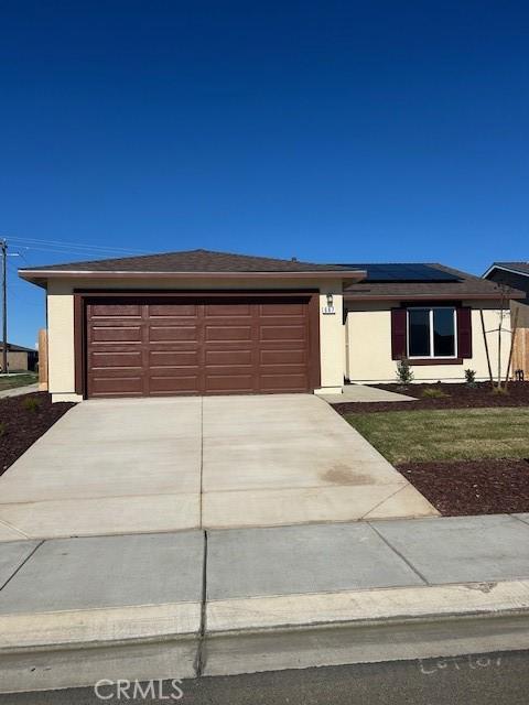 view of front of property with a garage and solar panels