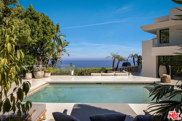 view of swimming pool with a patio and a water view