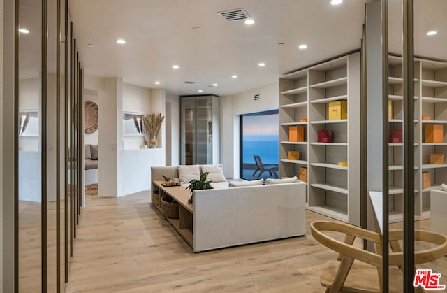 living room featuring a water view and light wood-type flooring