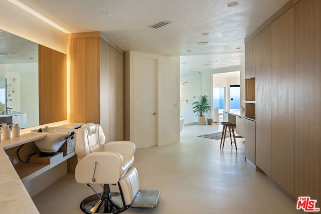 interior space with sink, concrete flooring, and a water view