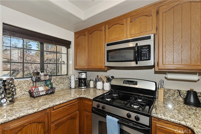 28050 State Highway 189 Unit 212, Lake Arrowhead, CA 92352 - kitchen featuring stainless steel appliances, brown cabinets, and light stone counters