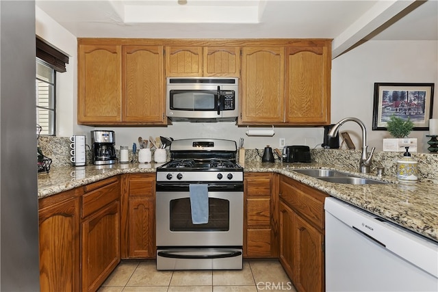 28050 State Highway 189 Unit 212, Lake Arrowhead, CA 92352 - kitchen with stainless steel appliances, light stone counters, light tile patterned floors, and brown cabinetry