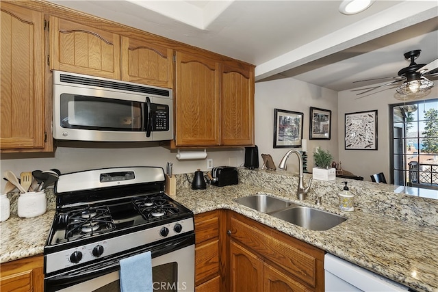 28050 State Highway 189 Unit 212, Lake Arrowhead, CA 92352 - kitchen featuring stainless steel appliances, ceiling fan, brown cabinetry, a peninsula, and light stone counters