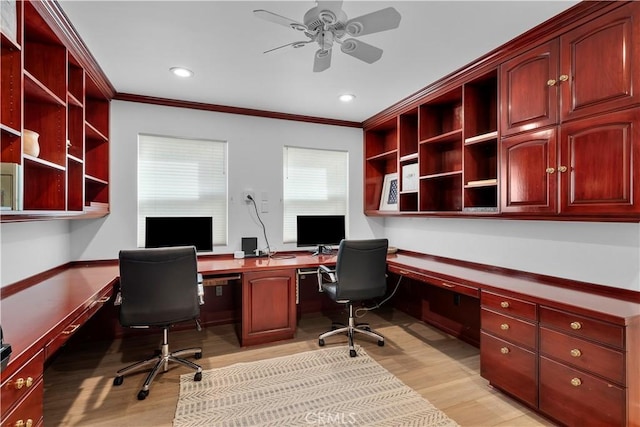 office featuring ceiling fan, ornamental molding, built in desk, and light hardwood / wood-style flooring