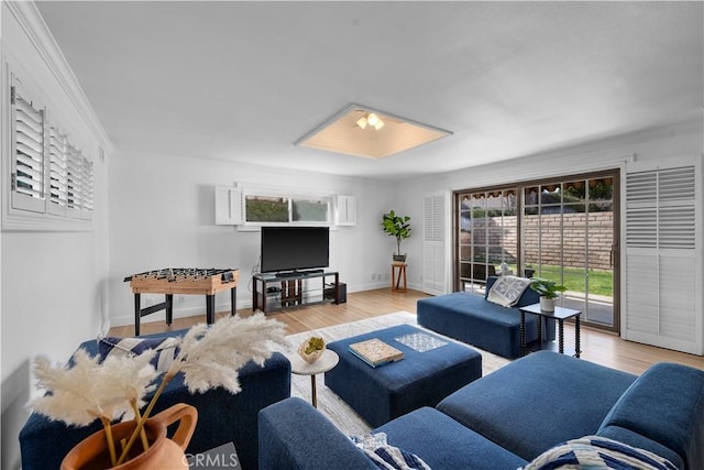 living room with crown molding and light wood-type flooring