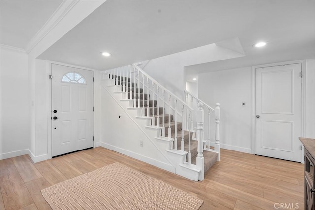 entryway featuring crown molding and light wood-type flooring