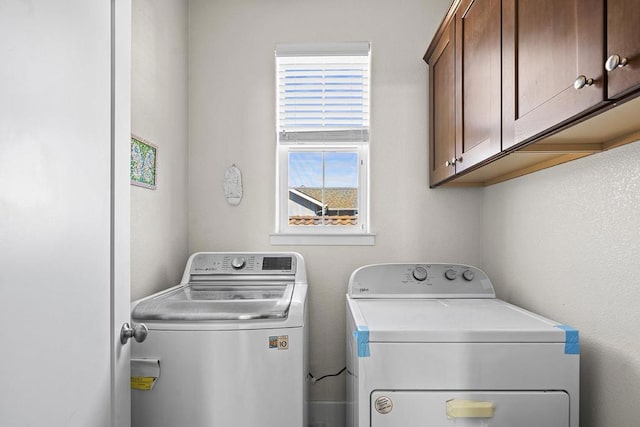 laundry area with washer and clothes dryer and cabinets