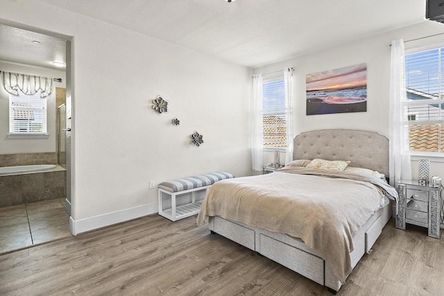 bedroom featuring hardwood / wood-style flooring and ensuite bathroom