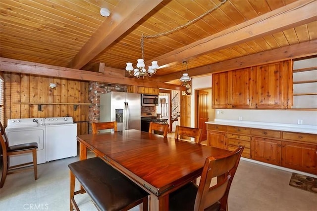 dining area featuring beamed ceiling, washing machine and clothes dryer, a chandelier, and wood ceiling