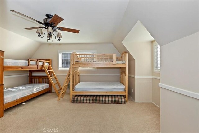 bedroom with vaulted ceiling, light colored carpet, and ceiling fan