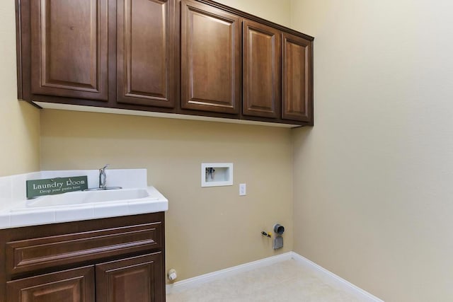 laundry area featuring gas dryer hookup, cabinets, sink, and hookup for a washing machine