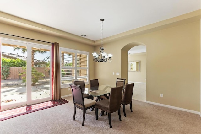 dining area featuring an inviting chandelier and light colored carpet