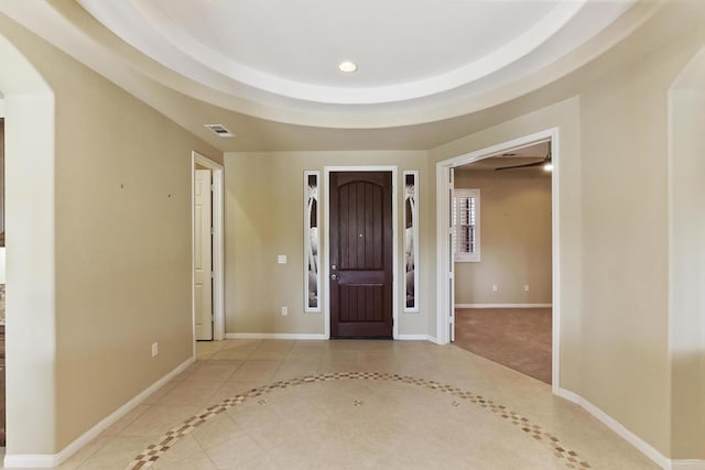 tiled entryway featuring a tray ceiling