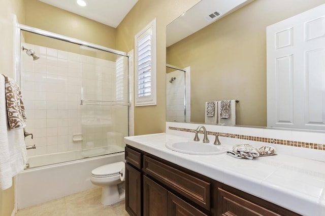 full bathroom featuring vanity, tiled shower / bath, tile patterned floors, and toilet