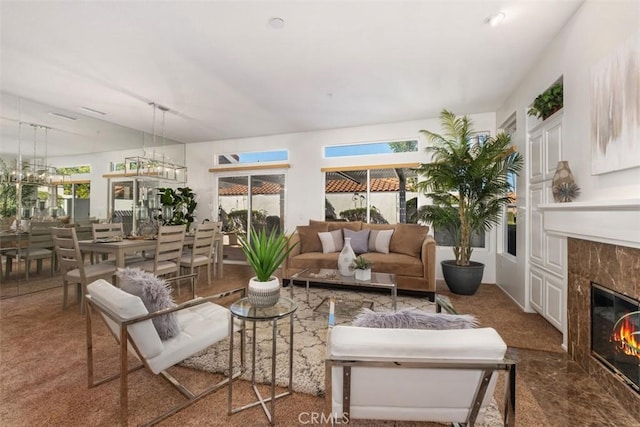 living area featuring a high end fireplace and a chandelier