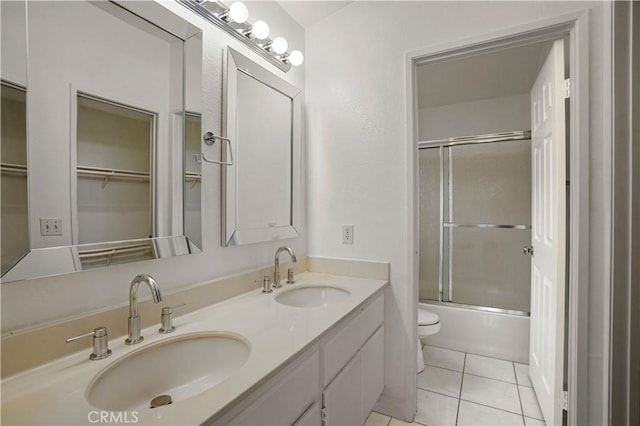 full bathroom with vanity, combined bath / shower with glass door, tile patterned floors, and toilet