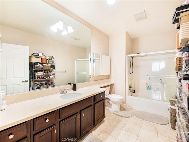 full bathroom with toilet, vanity, bath / shower combo with glass door, and tile patterned flooring