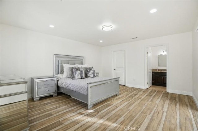 bedroom featuring ensuite bathroom and light hardwood / wood-style flooring