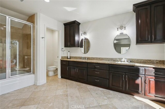 full bathroom featuring vanity, toilet, tile patterned flooring, and combined bath / shower with glass door