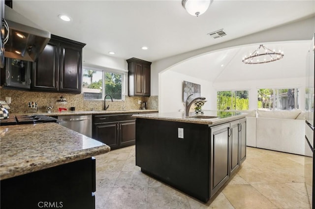 kitchen with sink, extractor fan, stainless steel dishwasher, a kitchen island with sink, and backsplash