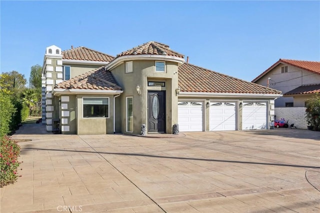 mediterranean / spanish home featuring a garage