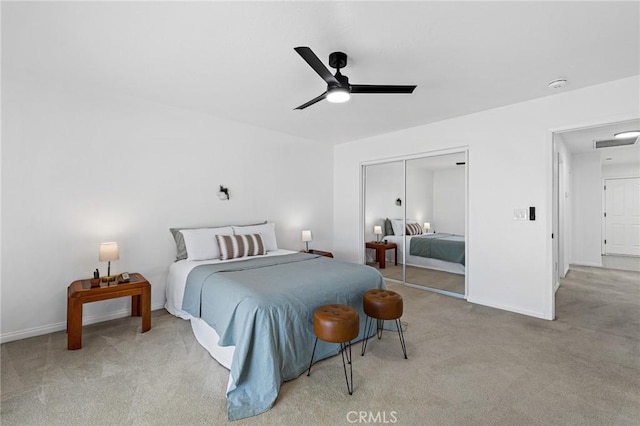 bedroom featuring light carpet, ceiling fan, and a closet