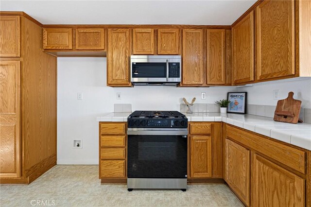 kitchen featuring gas stove and tile counters