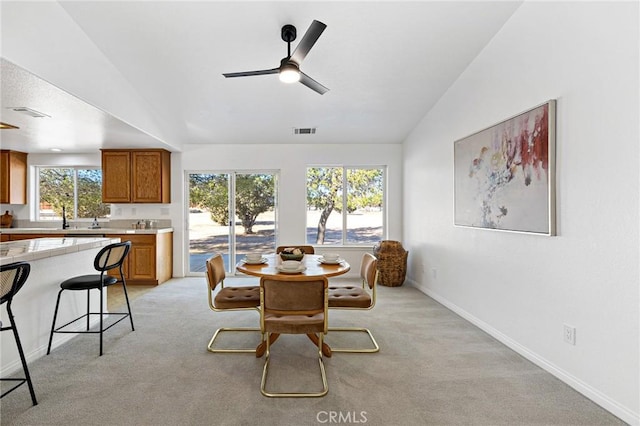 dining space featuring light carpet, sink, vaulted ceiling, and ceiling fan