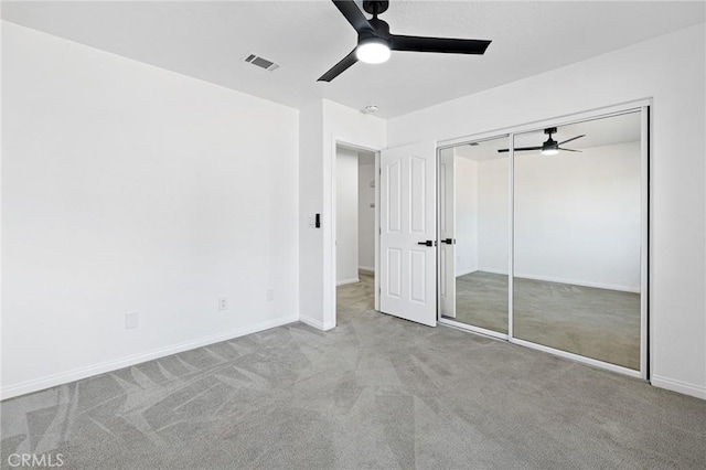 unfurnished bedroom with light colored carpet, a closet, and ceiling fan