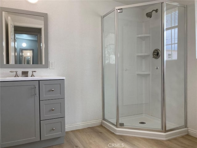 21483 Main St, Barstow, CA 92311 - bathroom featuring vanity, hardwood / wood-style floors, and walk in shower