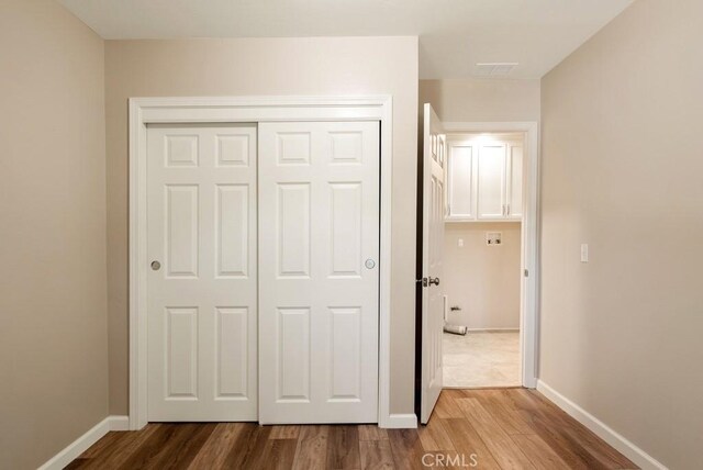 unfurnished bedroom with hardwood / wood-style flooring and a closet