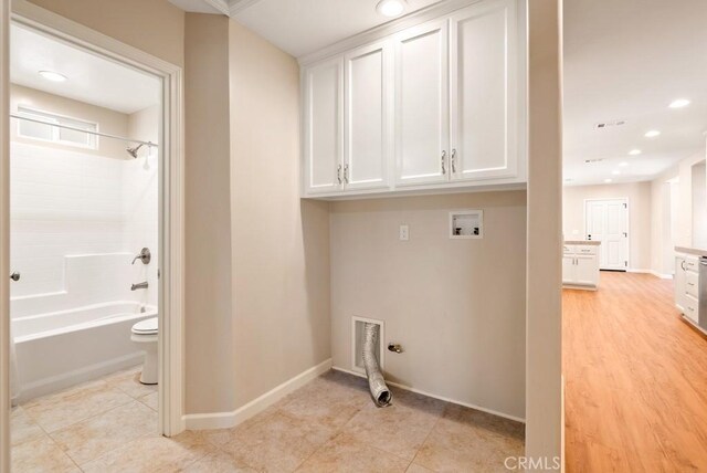 laundry room featuring washer hookup, light tile patterned floors, and cabinets