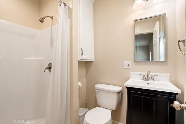 bathroom with walk in shower, vanity, and toilet