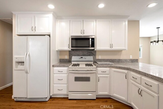 kitchen featuring pendant lighting, white appliances, and white cabinets