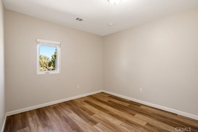 spare room with hardwood / wood-style flooring