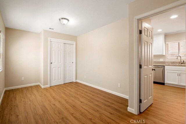 interior space with sink, light wood-type flooring, and a closet