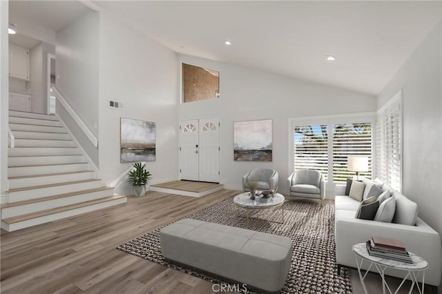 living room with hardwood / wood-style flooring and high vaulted ceiling