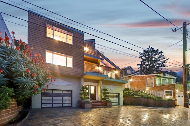 view of front of house featuring a garage and a balcony