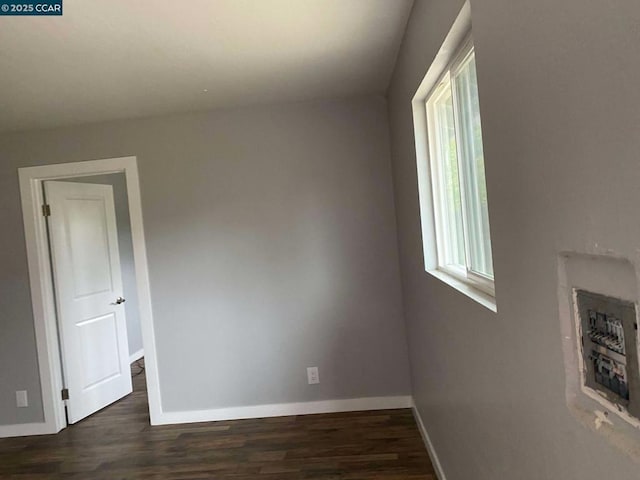 empty room with dark hardwood / wood-style flooring